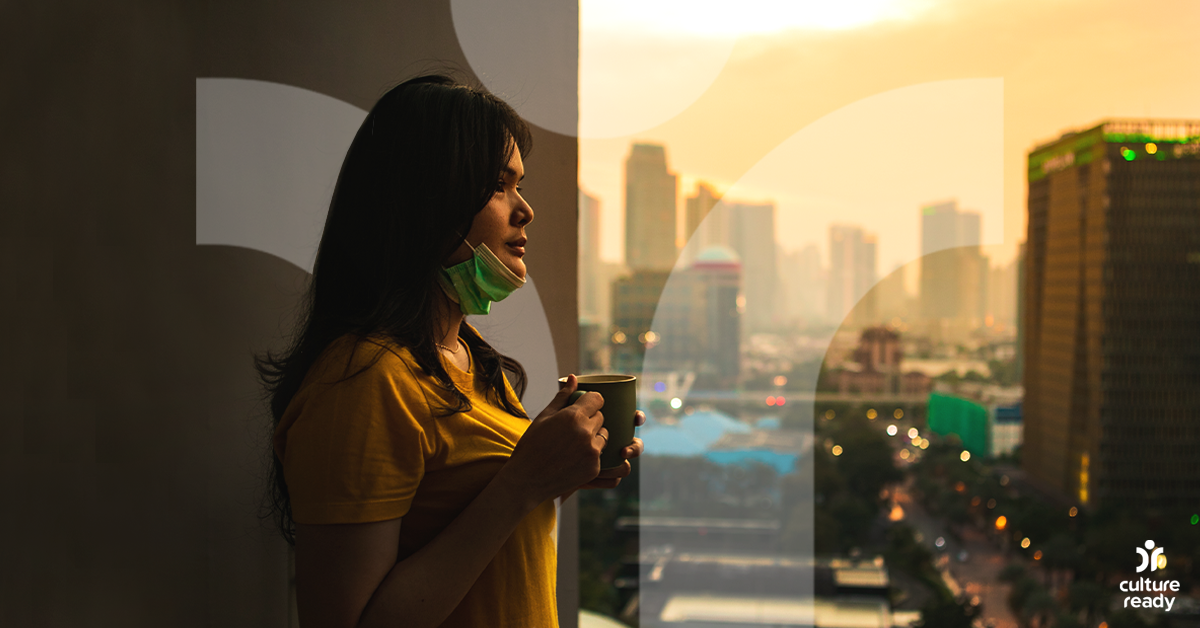 Image of a woman standing on a balcony in an urban setting